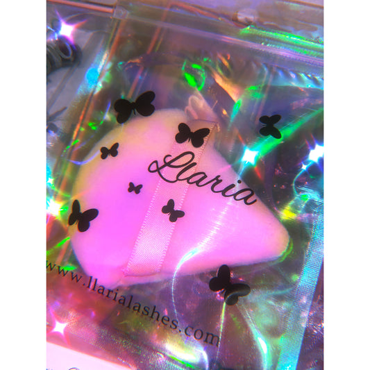 pink powder puff sponge makeup applicator in holographic makeup pouch.